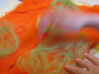 blurred hand in motion making orange & green felt 